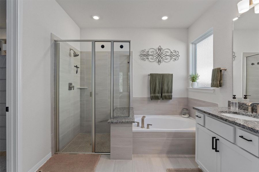 Full bathroom with vanity, a garden tub, a shower stall, and recessed lighting