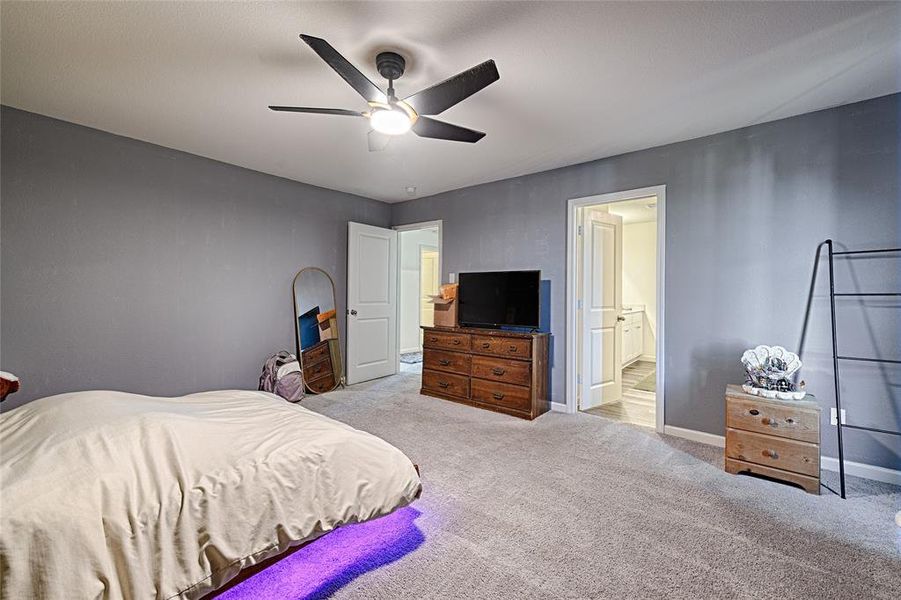Bedroom featuring light colored carpet and a ceiling fan Bedroom featuring light colored carpet and a ceiling fan