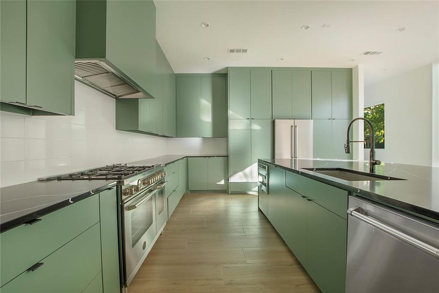 Kitchen with sink, premium appliances, and green cabinets