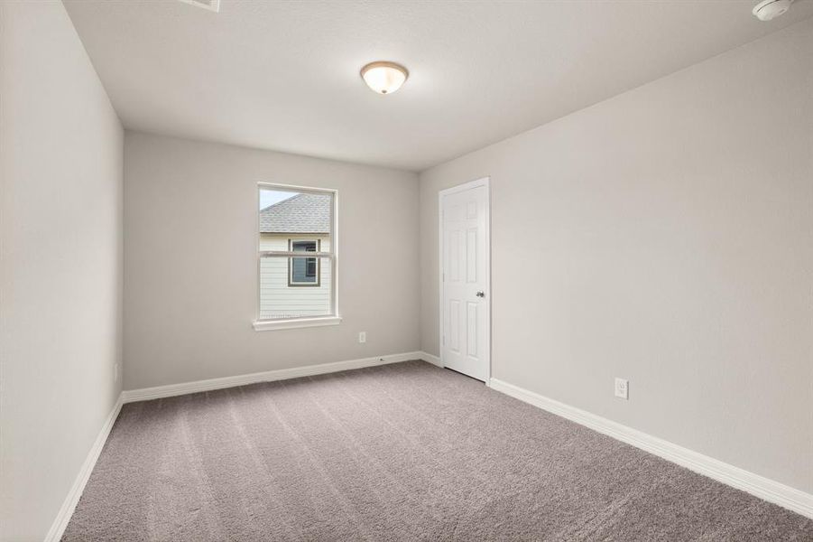 Your secondary bedroom features plush carpet, fresh paint, closet, and a large window that lets in plenty of natural lighting.