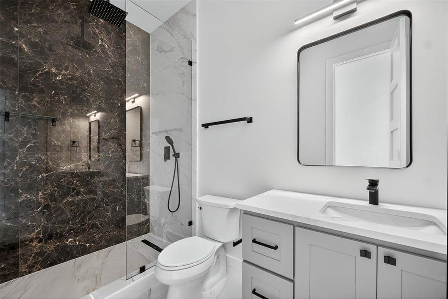 Bathroom featuring a marble finish shower, vanity, and marble finish flooring