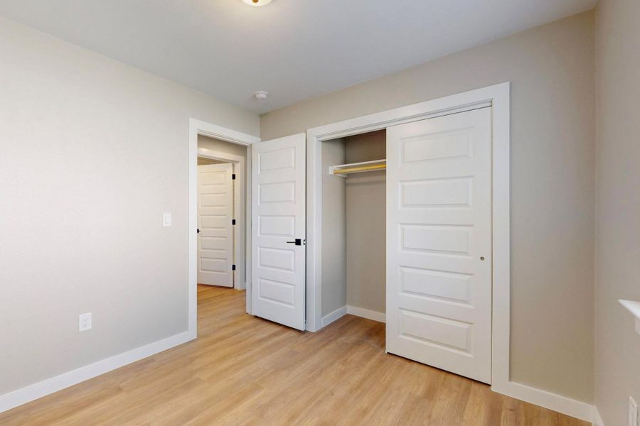 Unfurnished bedroom with a closet, baseboards, and light wood finished floors