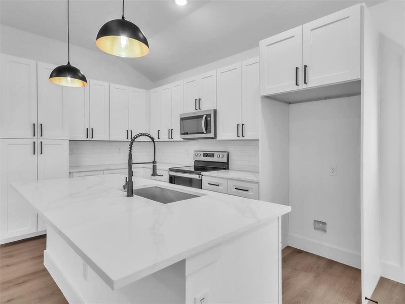 Kitchen with stainless steel appliances, a sink, white cabinetry, and tasteful backsplash Kitchen with stainless steel appliances, a sink, white cabinetry, and tasteful backsplash
