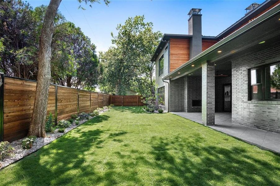 Expansive lawn bordered by a wood privacy fence and mature trees Expansive lawn bordered by a wood privacy fence and mature trees