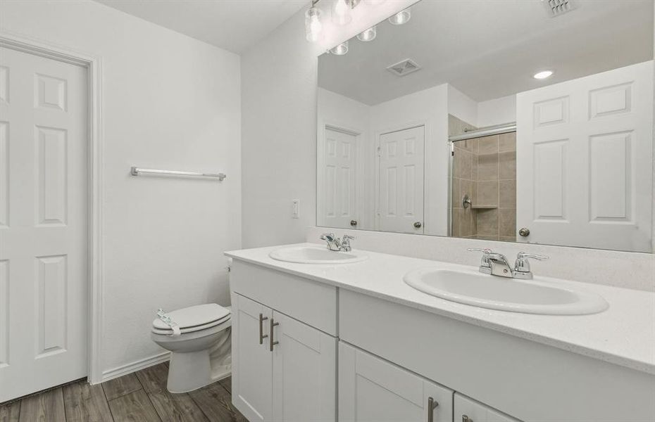 Modern secondary bath with dual sinks and upgraded finishes *Real home pictured