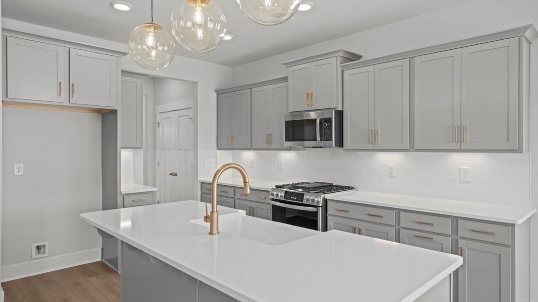 Vibrant and open kitchen centered around a 7-foot island with elegant pendant lighting above