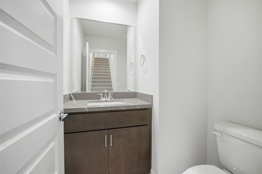 Sleek and modern half bathroom featuring a stylish vanity and a contemporary design, perfect for guests and convenience.