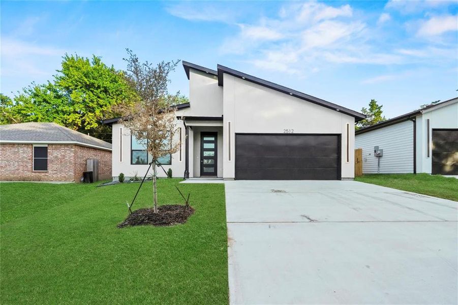 Modern home with stucco siding, concrete driveway, a front lawn, and a garage Modern home with stucco siding, concrete driveway, a front lawn, and a garage