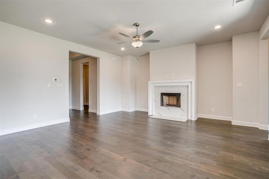 Unfurnished living room with ceiling fan, dark hardwood / wood-style floors, and a fireplace