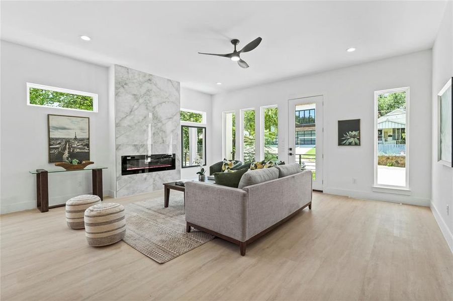 Living room featuring a fireplace, recessed lighting, a ceiling fan, and light wood-style flooring Living room featuring a fireplace, recessed lighting, a ceiling fan, and light wood-style flooring