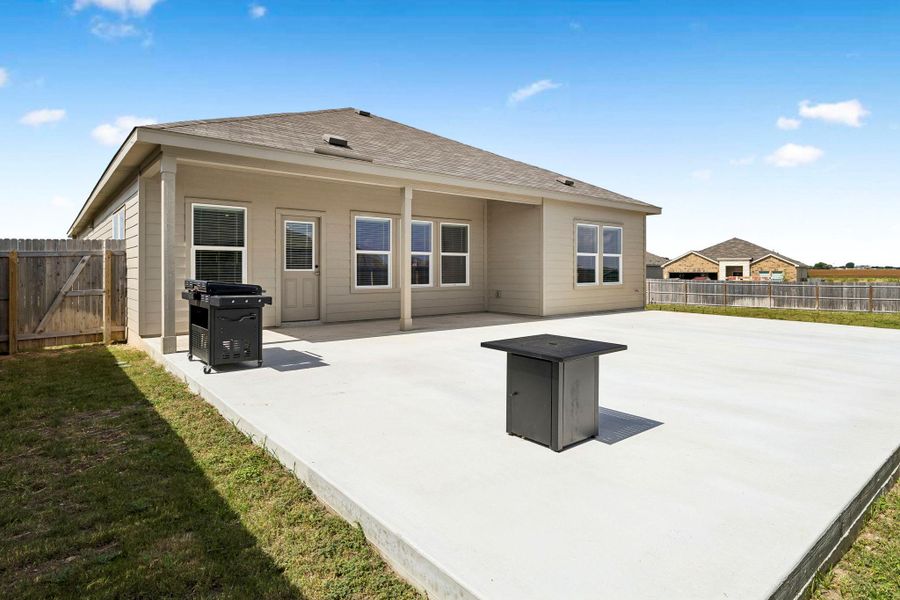 An expansive concrete patio provides ample outdoor living space behind this well-maintained residence.