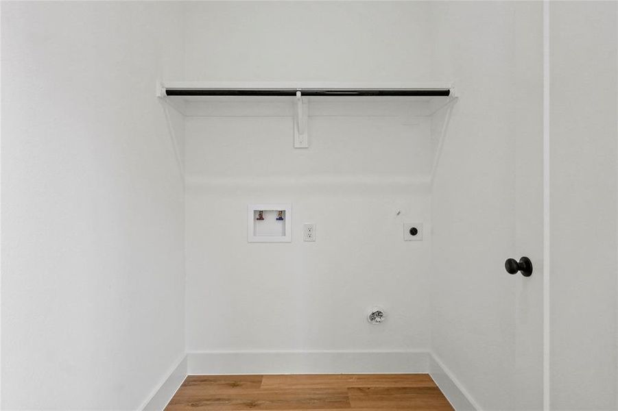 Laundry room with light wood finished floors, hookup for a washing machine, and hookup for an electric dryer