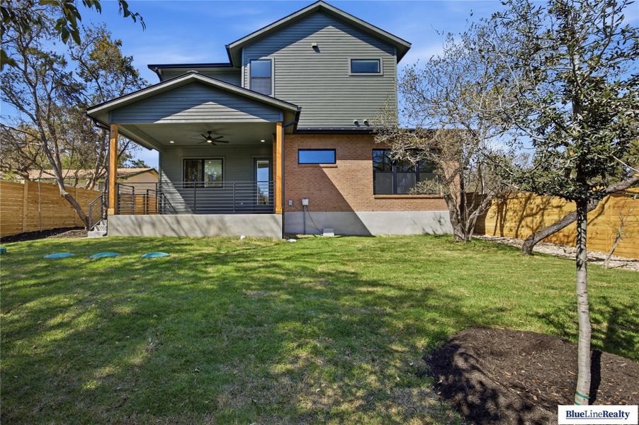 Back of house featuring ceiling fan and brick siding