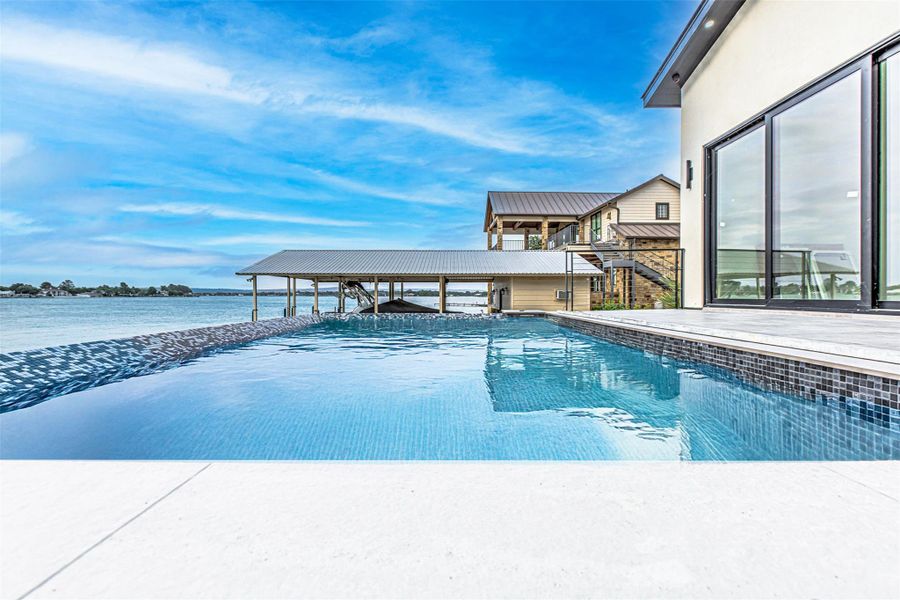 Outdoor pool with a beach view and a water view