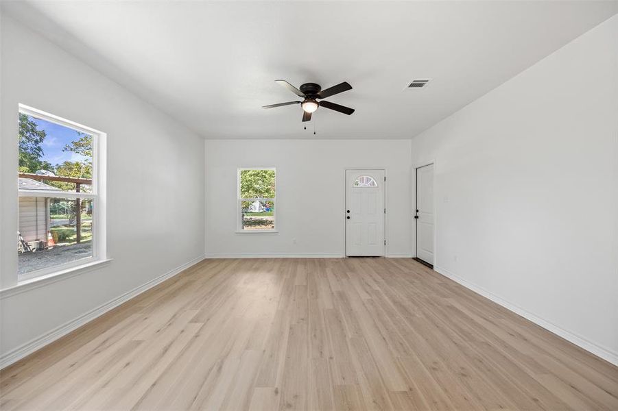 Unfurnished living room featuring light wood finished floors and ceiling fan