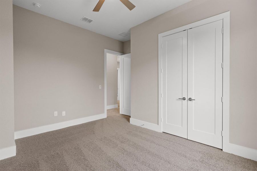 A well-lit room showcases plush carpeting and modern white doors, ready for personalized touches. A well-lit room showcases plush carpeting and modern white doors, ready for personalized touches.