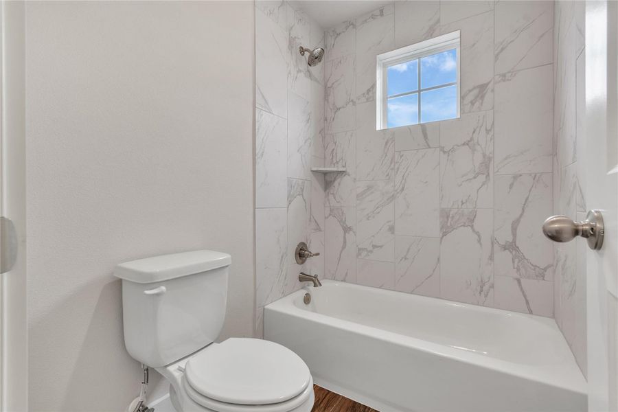 A pristine bathroom features a classic bathtub and elegant tiled walls, offering a serene escape.