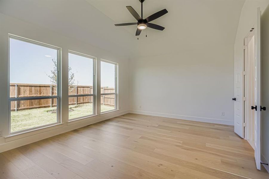 Empty room with light wood-style floors and a ceiling fan