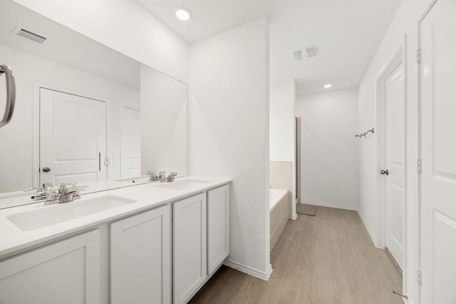 Twin vanities and a deep soaking tub create a luxurious bathroom retreat.