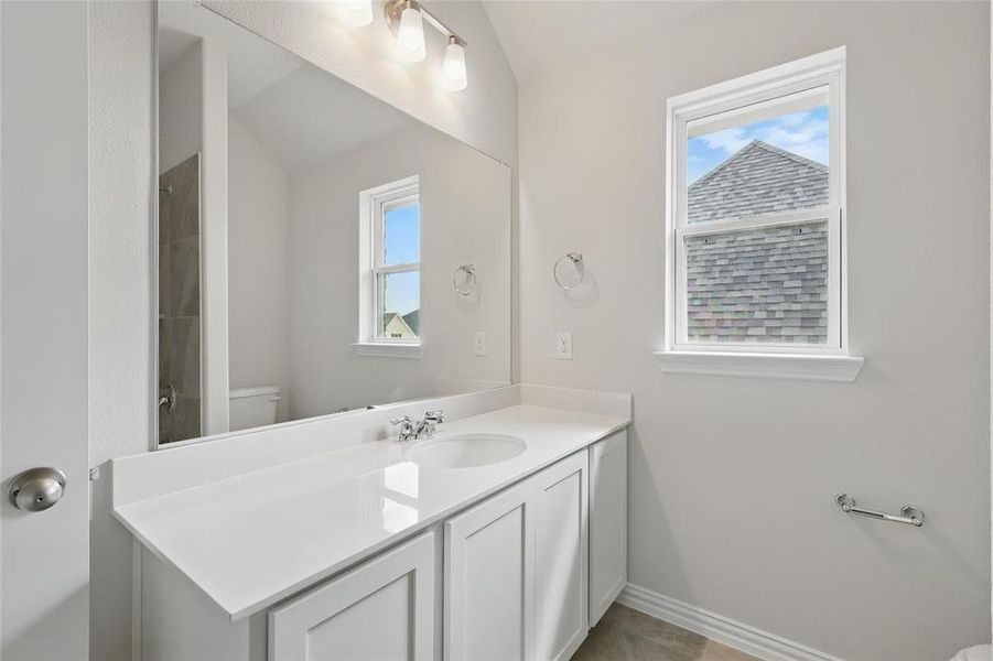 Full bath with vanity, a shower, and lofted ceiling