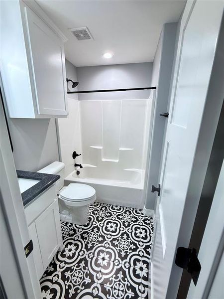 Bathroom featuring vanity, tile patterned flooring, and shower / tub combination Bathroom featuring vanity, tile patterned flooring, and shower / tub combination
