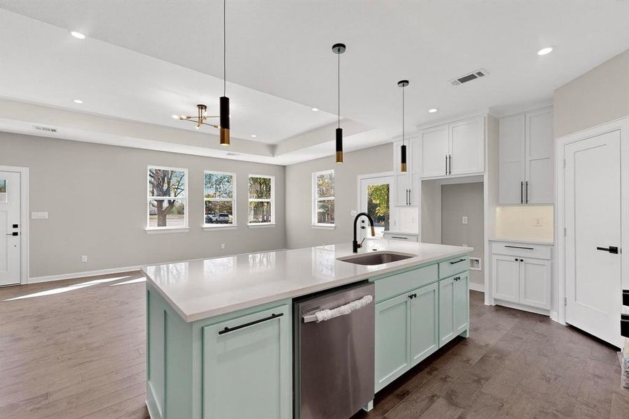 Kitchen with green cabinetry, stainless steel dishwasher, an island with sink, white cabinetry, and dark wood finished floors Kitchen with green cabinetry, stainless steel dishwasher, an island with sink, white cabinetry, and dark wood finished floors