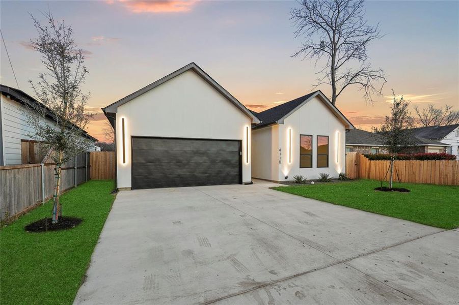 View of front facade featuring a yard and a garage