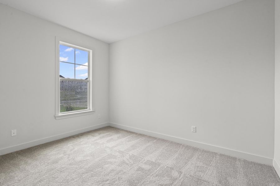 Spare room featuring light carpet and baseboards
