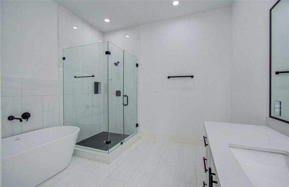 The clean white tiles and recessed lighting contribute to a bright and airy atmosphere.