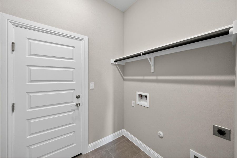 Washroom featuring hookup for a washing machine, gas dryer hookup, light tile patterned floors, and hookup for an electric dryer Washroom featuring hookup for a washing machine, gas dryer hookup, light tile patterned floors, and hookup for an electric dryer