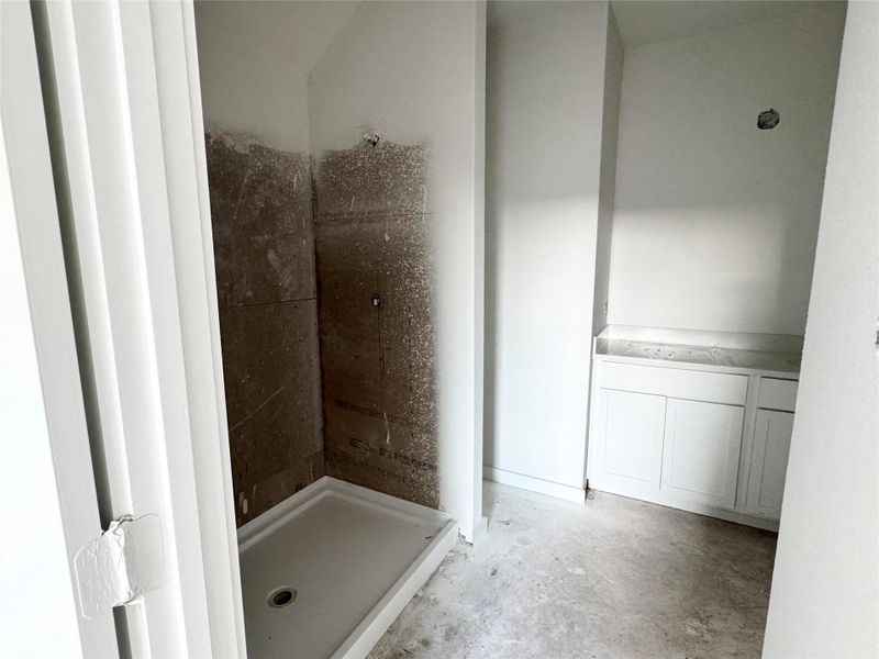 Bathroom featuring a stall shower and unfinished concrete flooring