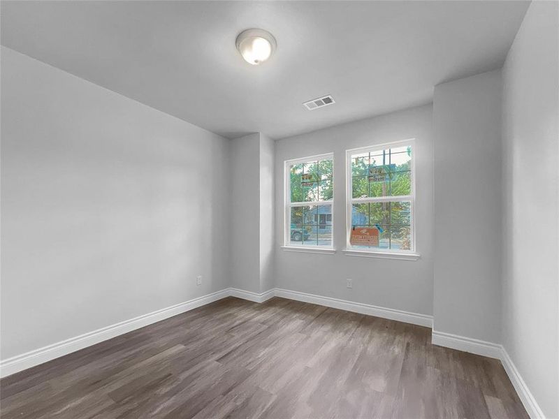 Empty room with dark wood-style floors and baseboards Empty room with dark wood-style floors and baseboards
