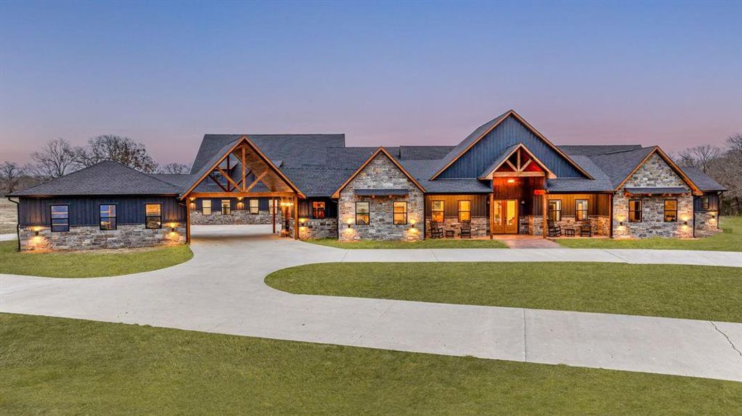 Craftsman-style home with stone siding, a front lawn, and covered porch
