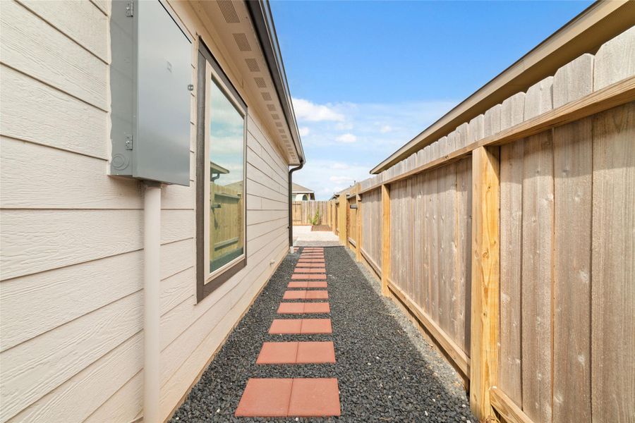 Side yard pathway with clean lines and low-maintenance landscaping, offering easy access around the home.