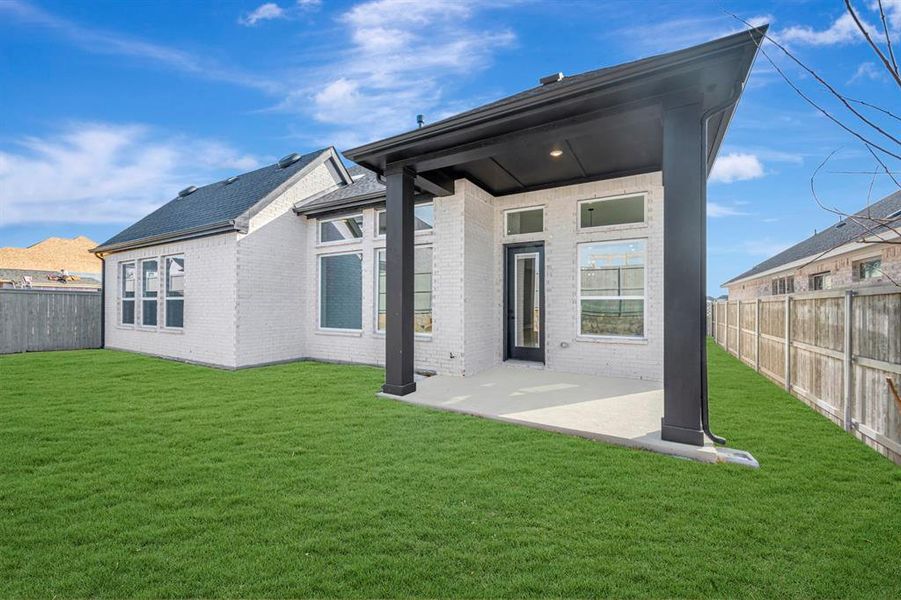 Back of property featuring a fenced backyard, a patio, and brick siding