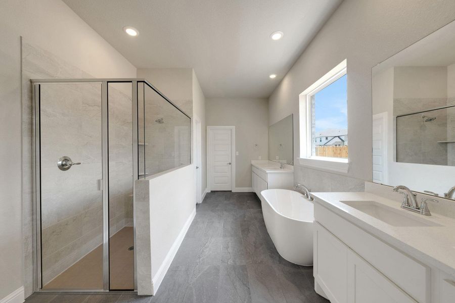 Bathroom featuring two vanities, a stall shower, a soaking tub, recessed lighting, and marble finish floors Bathroom featuring two vanities, a stall shower, a soaking tub, recessed lighting, and marble finish floors