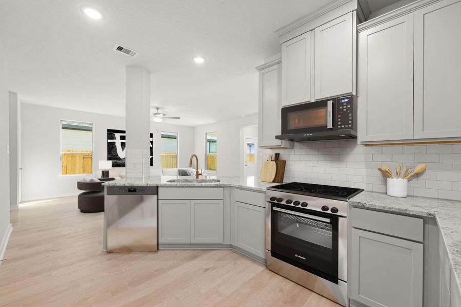 This bright and contemporary kitchen features sleek cabinetry, stainless steel appliances, granite countertops, and a spacious breakfast bar that overlooks the main living area. The open layout and clean design make it both functional and inviting. This bright and contemporary kitchen features sleek cabinetry, stainless steel appliances, granite countertops, and a spacious breakfast bar that overlooks the main living area. The open layout and clean design make it both functional and inviting.