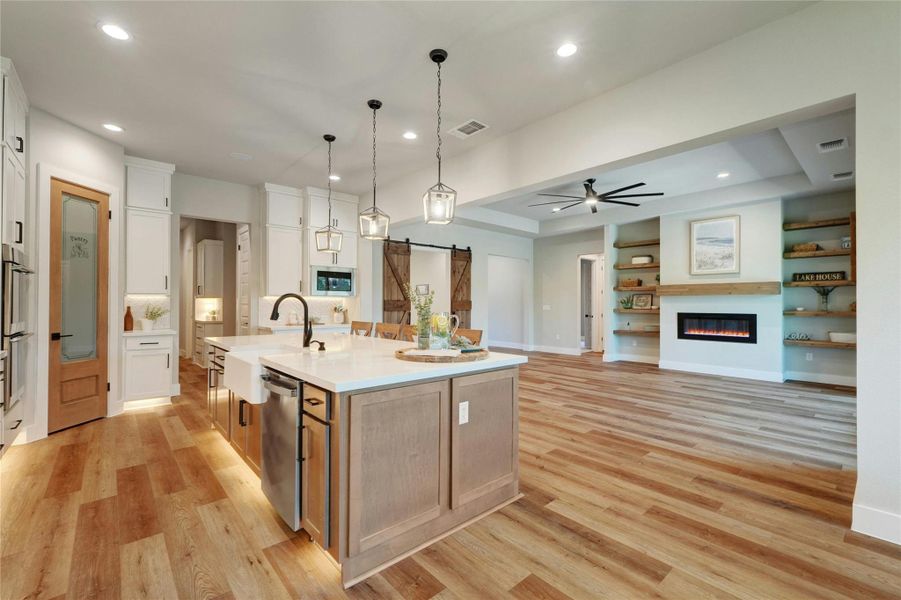 Spacious kitchen and living area featuring wood-finish flooring