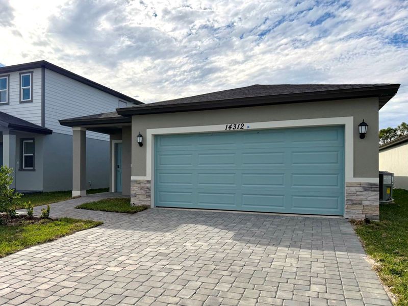 Front exterior of a new home in Meritage Homes at Terra Lago - Premier Series, Indiantown, FL, highlighting curb appeal (Image 2). Front exterior of a new home in Meritage Homes at Terra Lago - Premier Series, Indiantown, FL, highlighting curb appeal (Image 2).