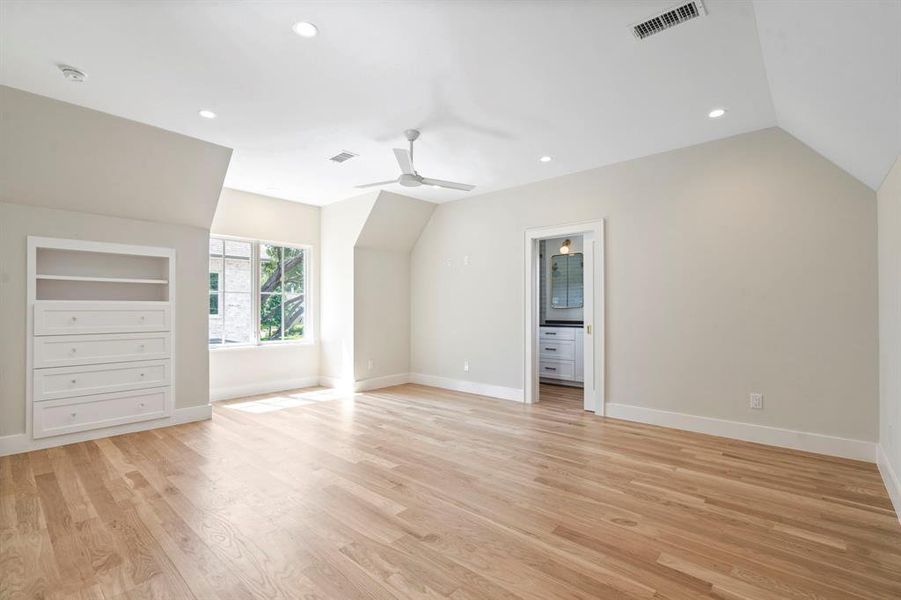 Bonus room featuring built in features, light hardwood / wood-style flooring, ceiling fan, and vaulted ceiling