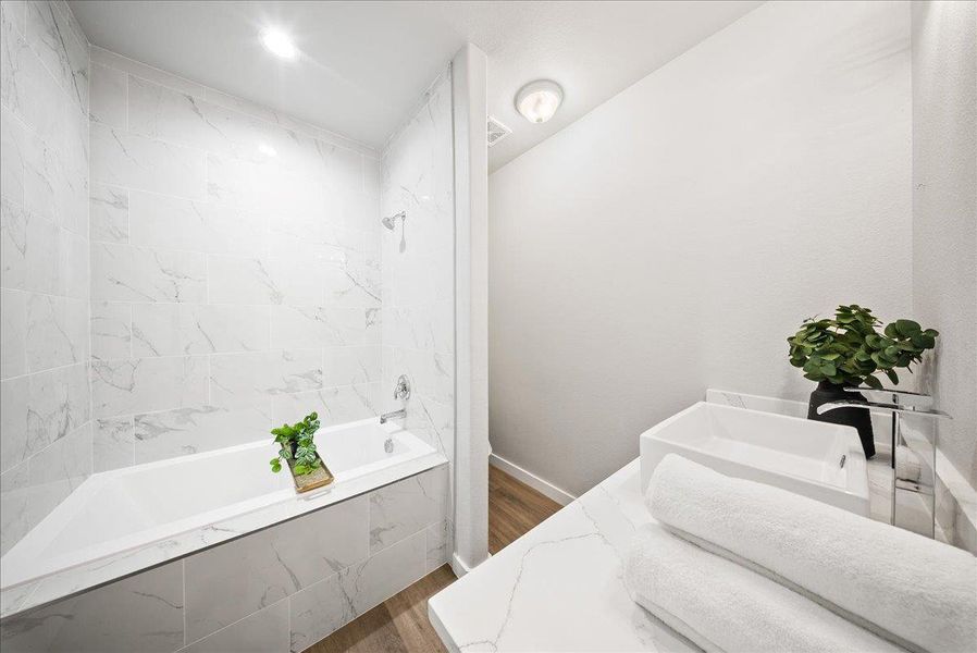 Bathroom with tiled shower / bath, dark wood-style flooring, and vanity Bathroom with tiled shower / bath, dark wood-style flooring, and vanity