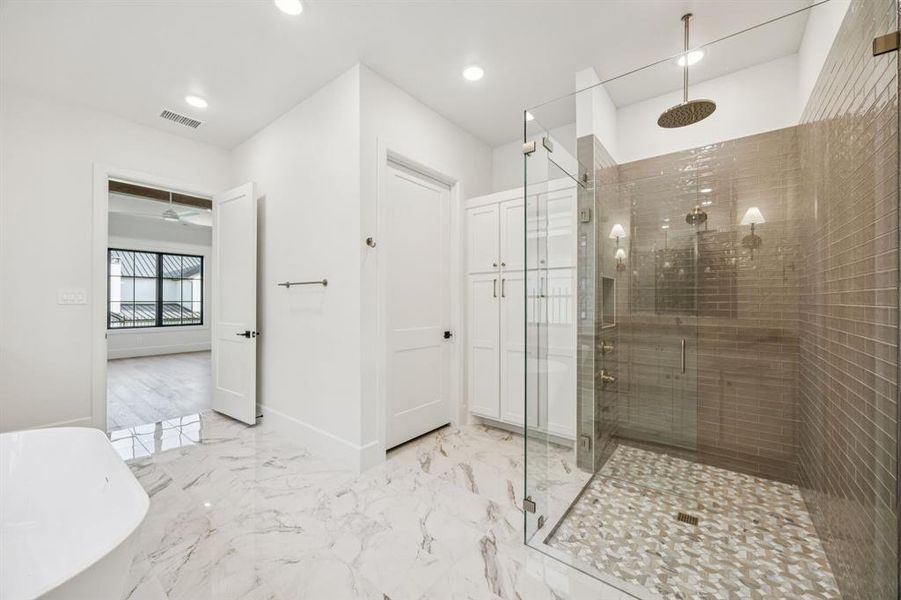 Full bathroom featuring a shower stall, a freestanding tub, recessed lighting, and marble finish floors Full bathroom featuring a shower stall, a freestanding tub, recessed lighting, and marble finish floors