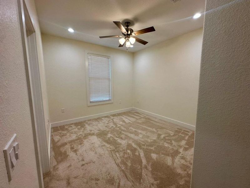 Unfurnished room featuring a textured wall, light carpet, recessed lighting, and ceiling fan