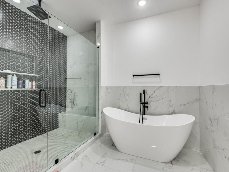 Bathroom with tile walls, recessed lighting, marble tiled flooring, a marble finish shower, and a freestanding bath