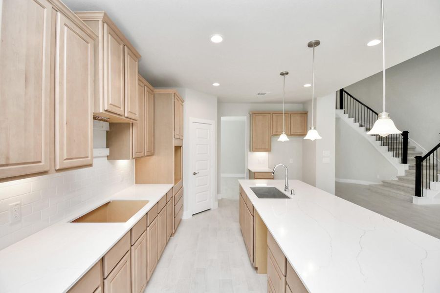 The extended counter area adds both practicality and style, making meal preparation a breeze. Every detail is thoughtfully designed to enhance the kitchen's functionality and aesthetic appeal. Sample photo of completed home with similar floor plan. Actual colors and selections may vary.