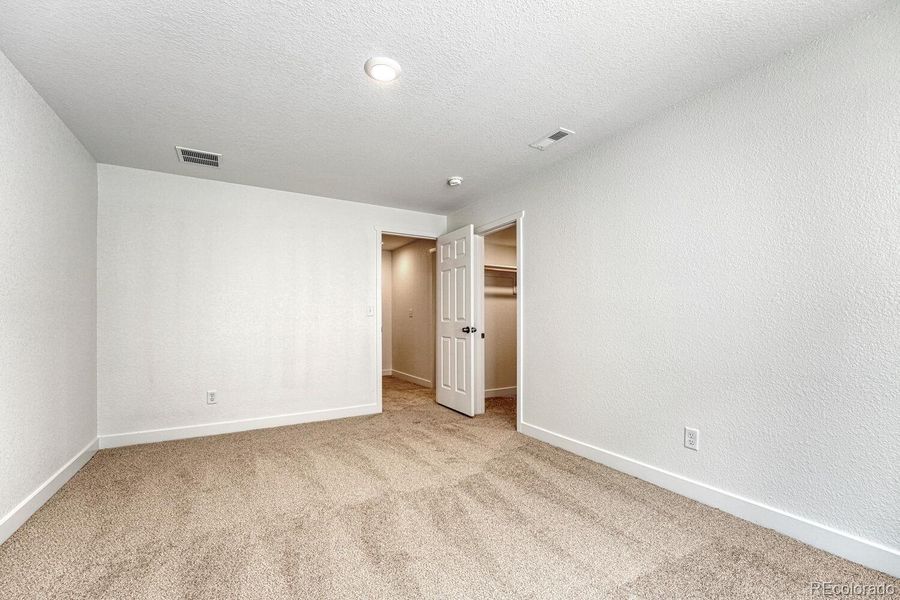 Walk-in closet for use as a wardrobe or extra storage.