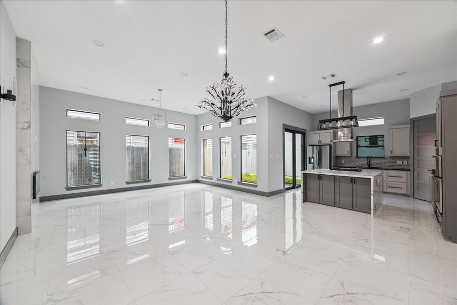 A wall of picture windows brightens the living room, where a tile fireplace adds modern appeal and neutral colors offer design flexibility. Open-concept styling enhances the connection to the kitchen and dining space. A wall of picture windows brightens the living room, where a tile fireplace adds modern appeal and neutral colors offer design flexibility. Open-concept styling enhances the connection to the kitchen and dining space.