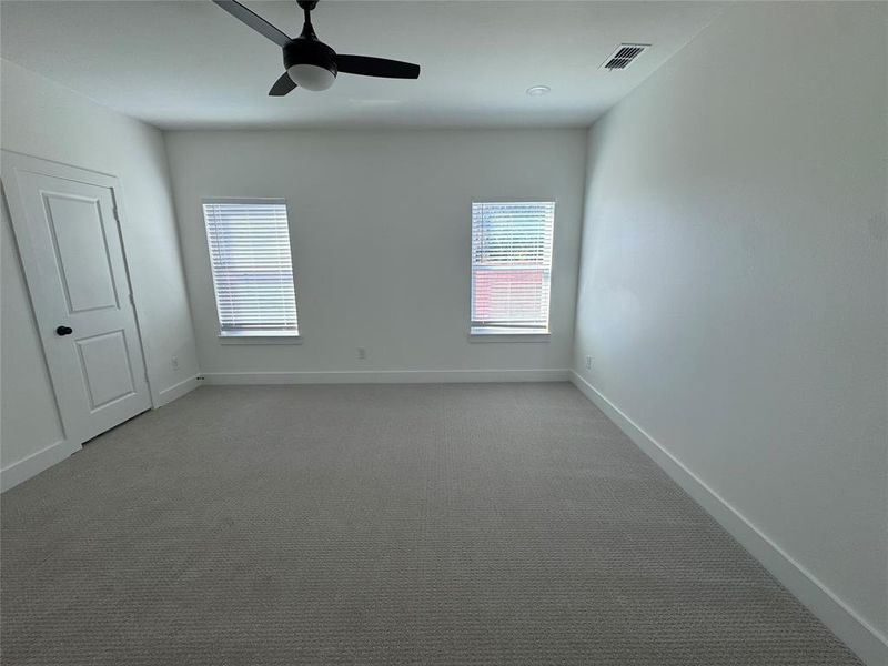 Carpeted spare room featuring ceiling fan