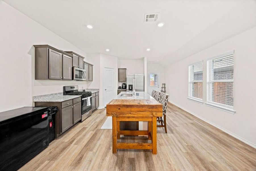 Kitchen featuring wood-finish flooring, recessed lighting, and white walls Kitchen featuring wood-finish flooring, recessed lighting, and white walls