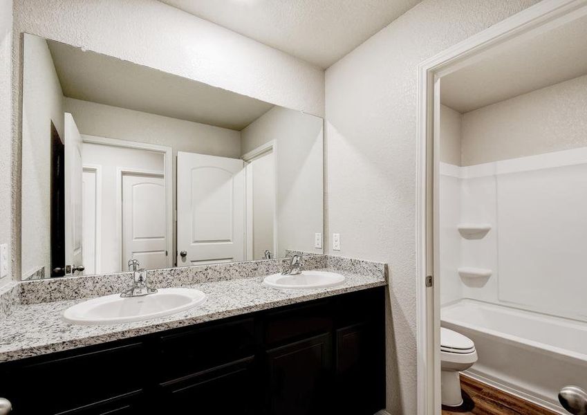 Secondary bathroom with granite countertops and a dual shower and tub.